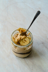 Creamy Peanut Butter Pie Dessert with Banana Slice and Chocolate Cake in Jar / Paleo Diet Cup.
