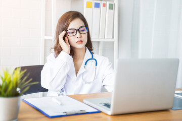 Medical health clinic beautiful Asian female doctor working using laptop researching diagnosing patient analysis healthcare provider service insurance, wearing uniform stethoscope, in modern office