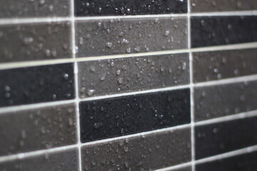 Closeup of water droplets on a shower wall.