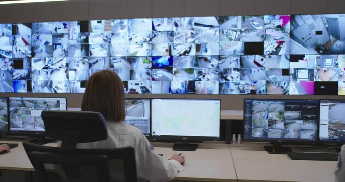 Slow motion footage of security control room operator at work, Security System Operator Looking At Cctv Footage