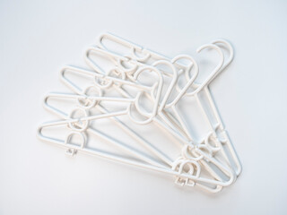 Fototapeta premium Pattern of white plastic hanger on white and pastel background color. Copy space provided.