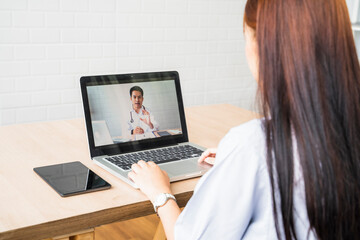 Asian woman laptop video call conference online appointment talking with doctor checkup examining diagnosing patient medical healthcare, at home modern office quarantine coronavirus covid-19 pandemic