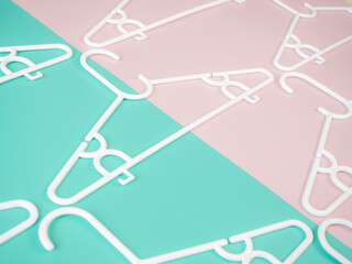 Pattern of white plastic hanger on white and pastel background color. Copy space provided.