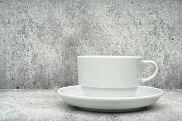 White cup with saucer on a light background. Dishes for coffee. Coffee cup