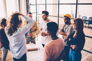 Crew of professional male and female designers discussing ideas during brainstorming session, colleagues having productive working process teamworking on project together in coworking office