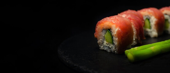 Sushi Stone With Tuna rolls Close Up On a Black Background