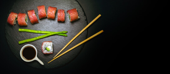 Sushi Plate With Tuna rolls And Sticks On a Black Background