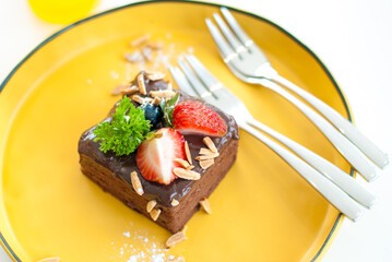 Strawberry chocolate cake on a yellow plate
