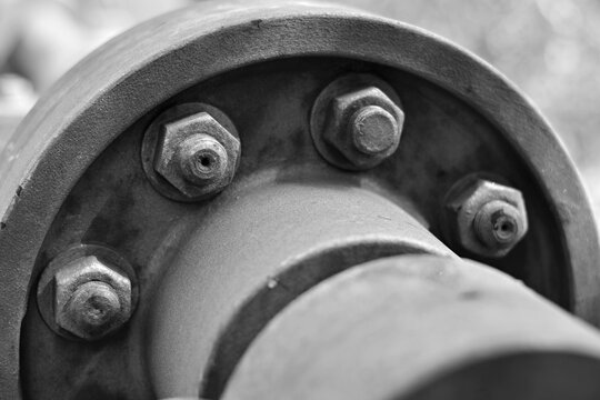Detalle de pernos y tuercas de una antigua brida de acero, blanco y negro