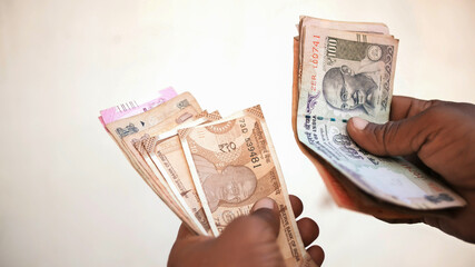 Man recounts indian rupee money.