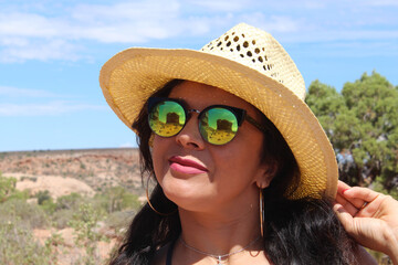 une jeune femme avec le reflet des montagnes dans ses lunettes solaires dans le parc national des arches aux Etats-unis