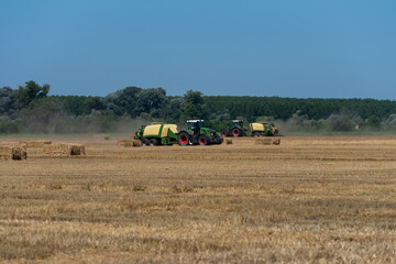 heavy machinery in the field performs agricultural work during the summer