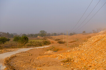 A loaded motorcycle goes down a dirt road.