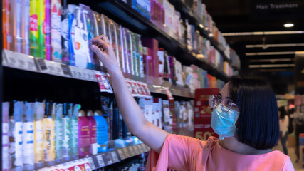 woman wearing a protective mask do grocery after open lockdown in supermarket, to protect and spread out of virus. new normal concept