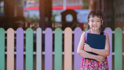 Asian little girl student wearing face shield during she going back to school after covid-19 quarantine.16:9 Style