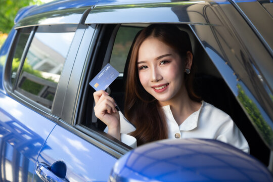 Young Asian Woman Driving A Car And Holding Credit Card