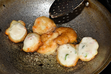 south indian cuisine - Vada or Medu vadai frying in coconut oil. Very popular south Indian snack.