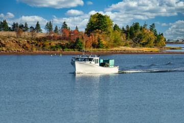Obraz premium Lobster fishing boat sailing into port in rural Prince Edward Island, Canada.