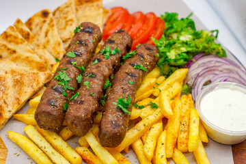 Chargrilled Greek / Arabic Lamb / Pork Skewers Served with Fries / Chips Salad Tzatziki Sauce Tomatoes Onions Lettuce