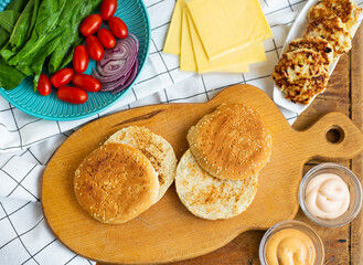 Preparation of all the ingredients for the preparation of a delicious bun burger, cutlet, cheese, salad, tomato, sauces.