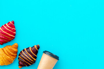 Coffee and croissants on blue table top view