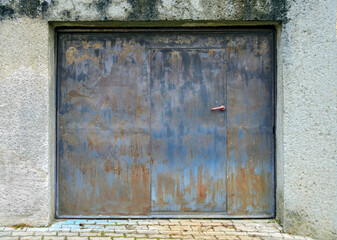 old rusty garage gate with integrated door for pedestrians