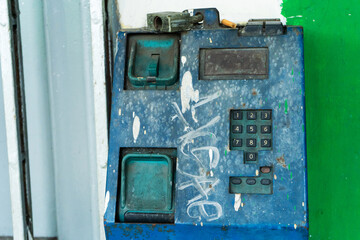 Fototapeta na wymiar Old broken payphone. Traces of poverty and devastation.