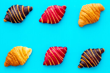 Set of croissants - chocolate, berry, classic - on blue table top view