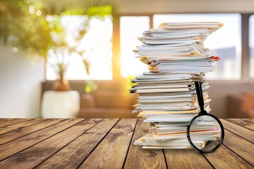 File folders with documents and magnifying glass on the desk