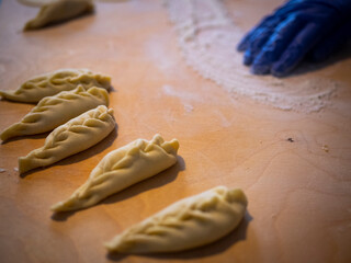 Closeup of chef's hands making and folding sardinian ravioli filled pasta