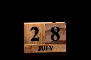 wooden calendar 28 July word on black background with copy space , selective focus at the calendar