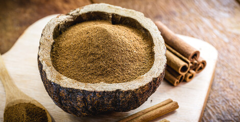 powdered cinnamon and stick, in a rustic wooden bowl, exotic cinnamon from Brazil.