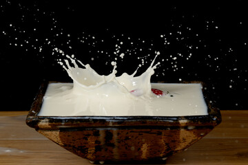 fresas salpicando leche dentro de un cuenco y formando figuras 