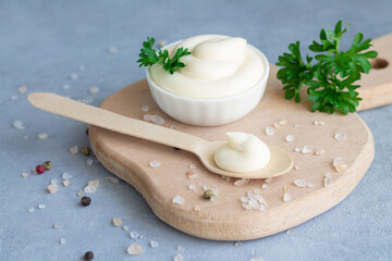 Bowl fresh organic homemade mayonnaise next to wooden spoon with mayo on wood board - obrazy, fototapety, plakaty