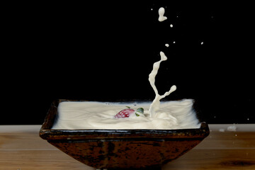 fresas salpicando leche dentro de un cuenco y formando figuras 