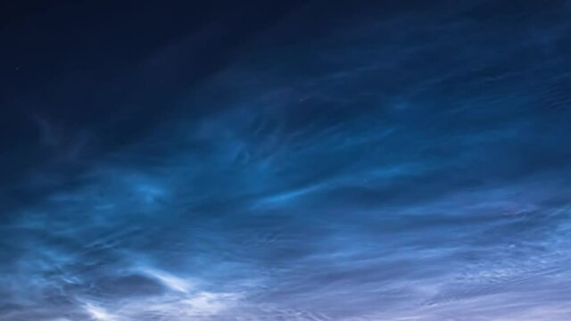 Night clouds. Noctilucent Clouds. Silvery clouds( Noctilucent Clouds), a rare sky phenomenon, beautiful white clouds soar across the blue night sky. Summer. Loop