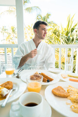 Man Holding Coffee Cup during Tropical Breakfast