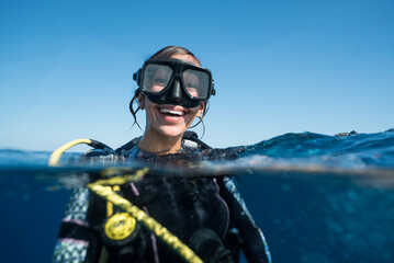 Woman SCUBA Diving Smiling in Ocean - obrazy, fototapety, plakaty