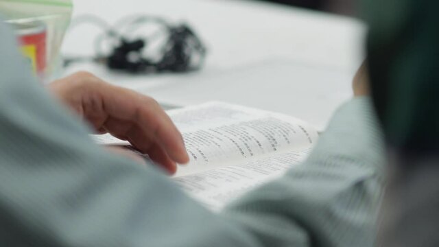 Man turning pages of Chinese Bible