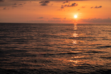 Sunset at sea. Red, yellow sky. Blue clouds. The sun falls into the water. Evening. Black Sea. Georgia.