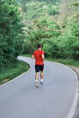 Young man running alone on an empty road