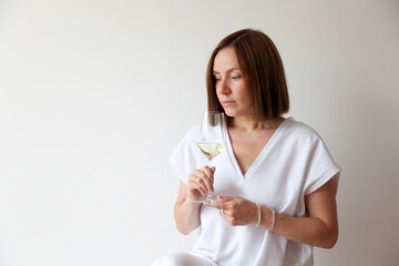 Caucasian brunette girl sommelier holding glass of white wine