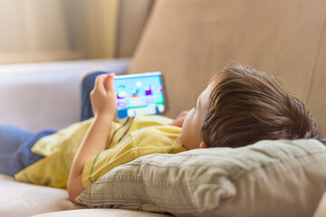 Boy using mobile smart phone at home. Сhild hands with a smartphone. Education, science,...