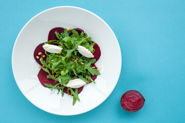 Vegetable salad of fresh beets, arugula, cottage cheese, pine nuts