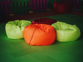 Bright multicolored chair bags on a green floor covering
