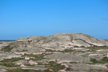 Large hill on Swedish coast on a sunny day with ocean and blue sky background