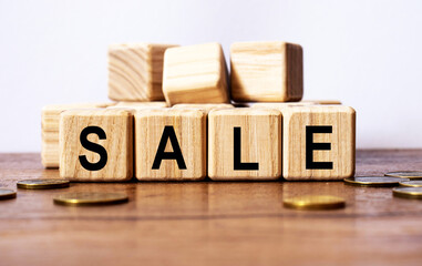 wooden cubes and SALE, coins, the concept of taxation, increase taxes and fees