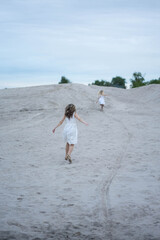 mom and daughter run on the sand