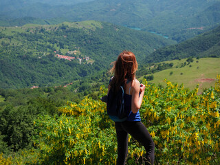 Obraz na płótnie Canvas young woman on a mounatin track watching panorama