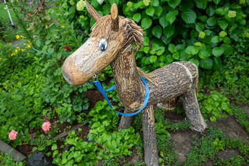 Wooden children's horse. Wooden horse for children stands in the garden
